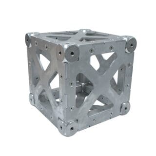 A metallic, hollow cube with reinforced edges and X-shaped cutouts on each face, featuring rounded corners and multiple screws securing the panels together—ideal for video lighting setups or mounting compact audio gear.