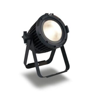 A black, cylindrical stage spotlight with a sturdy metal stand is angled upward. The lighting fixture is on, emitting a soft, bright glow. The background is plain white.