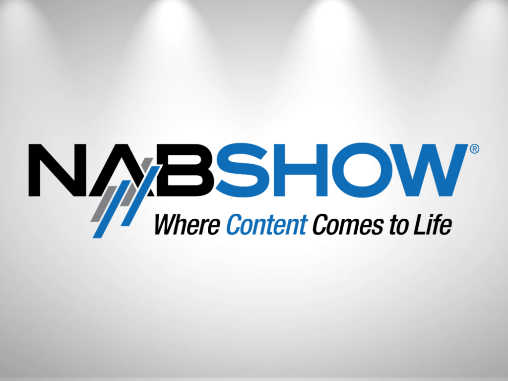 NAB Show logo with the tagline “Where Content Comes to Life” on a white background illuminated by three overhead spotlights.